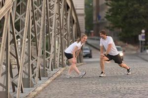 coppia che si riscalda e si allunga prima di fare jogging foto