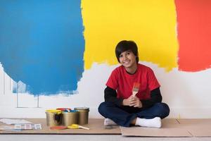 giovane ragazzo pittore che riposa dopo aver dipinto il muro foto