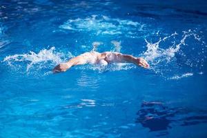 esercizio del nuotatore sulla piscina coperta foto