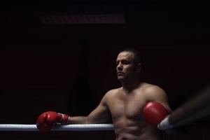 kick boxer appoggiato alle corde nell'angolo foto