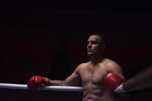 kick boxer appoggiato alle corde nell'angolo foto