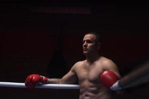 kick boxer appoggiato alle corde nell'angolo foto