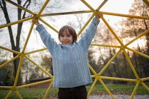 ragazzino carino che si diverte nel parco giochi foto