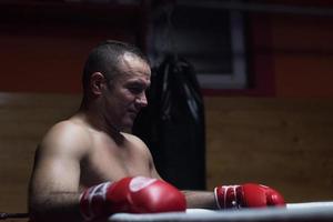 kick boxer appoggiato alle corde nell'angolo foto