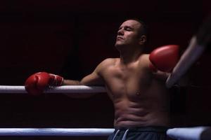 kick boxer appoggiato alle corde nell'angolo foto