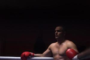 kick boxer appoggiato alle corde nell'angolo foto