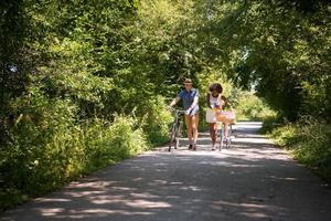 giovane coppia multietnica che fa un giro in bicicletta nella natura foto