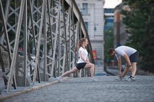 coppia che si riscalda e si allunga prima di fare jogging foto