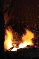 forgiare il fuoco nei fabbri dove vengono fabbricati strumenti di ferro foto