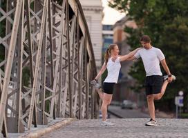 coppia che si riscalda e si allunga prima di fare jogging foto