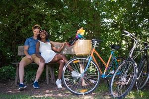 giovane coppia multietnica che fa un giro in bicicletta nella natura foto