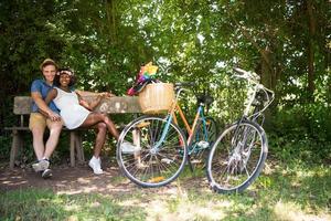 giovane coppia multietnica che fa un giro in bicicletta nella natura foto