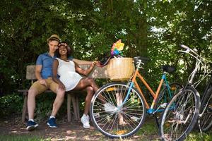 giovane coppia multietnica che fa un giro in bicicletta nella natura foto