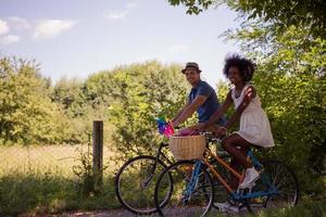 giovane coppia multietnica che fa un giro in bicicletta nella natura foto