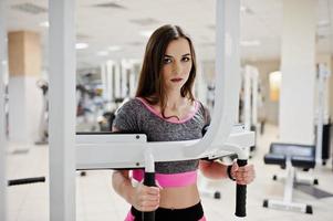 giovane ragazza magra sexy bruna che fa allenamento in palestra. foto