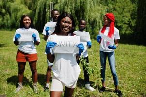 un gruppo di volontari africani felici tiene una lavagna vuota con il segno dell'unità nel parco. concetto di volontariato, carità, persone ed ecologia in africa. foto