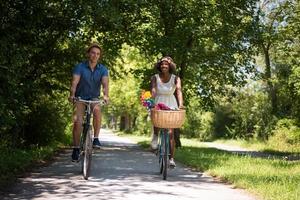 giovane coppia multietnica che fa un giro in bicicletta nella natura