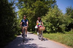 giovane coppia multietnica che fa un giro in bicicletta nella natura foto