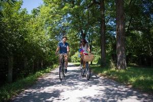 giovane coppia multietnica che fa un giro in bicicletta nella natura foto