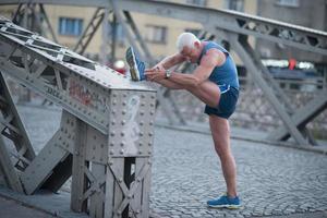 bell'uomo che si estende prima di fare jogging foto