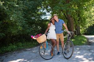 giovane coppia multietnica che fa un giro in bicicletta nella natura foto