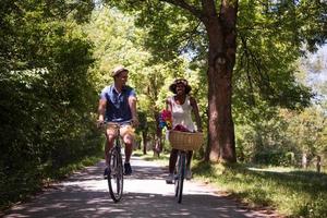 giovane coppia multietnica che fa un giro in bicicletta nella natura foto