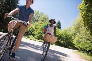 giovane coppia multietnica che fa un giro in bicicletta nella natura