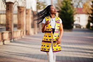 eleganti donne afroamericane in giacca gialla poste in strada con bevanda calda in tazza di carta usa e getta. foto