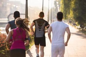 gruppo di giovani che fanno jogging in città foto