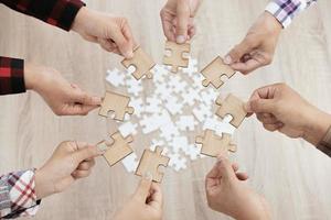 un gruppo di uomini d'affari che assemblano puzzle. il concetto di cooperazione, lavoro di squadra, aiuto e supporto negli affari. partnership di successo aziendale di squadra.
