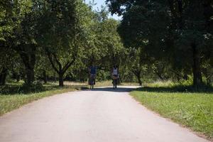 giovane coppia multietnica che fa un giro in bicicletta nella natura foto