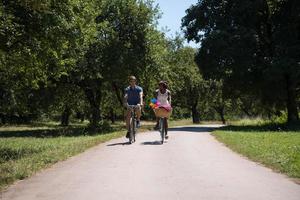 giovane coppia multietnica che fa un giro in bicicletta nella natura foto