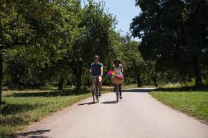 giovane coppia multietnica che fa un giro in bicicletta nella natura foto