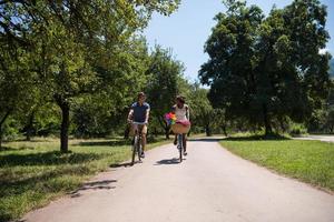 giovane coppia multietnica che fa un giro in bicicletta nella natura foto