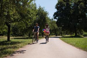 giovane coppia multietnica che fa un giro in bicicletta nella natura foto