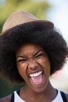 primo piano ritratto di una bella giovane donna afroamericana sorridente e alzando lo sguardo foto