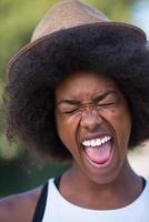 primo piano ritratto di una bella giovane donna afroamericana sorridente e alzando lo sguardo foto