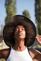 primo piano ritratto di una bella giovane donna afroamericana sorridente e alzando lo sguardo foto