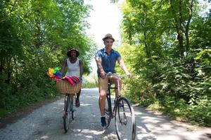 giovane coppia multietnica che fa un giro in bicicletta nella natura foto