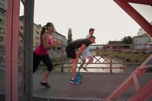 gruppo di giovani che fanno jogging attraverso il ponte foto