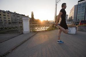 uomo atleta che si riscalda e si allunga foto