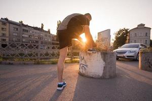 uomo che lega i lacci delle scarpe da corsa foto