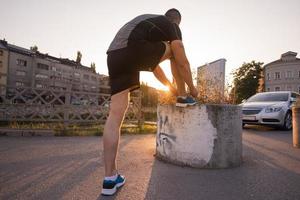 uomo che lega i lacci delle scarpe da corsa foto