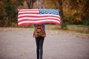 uomo africano in africa camicia tradizionale sul parco autunnale con bandiera usa. foto