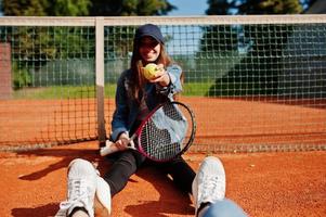 giovane ragazza sportiva con racchetta da tennis sul campo da tennis. foto