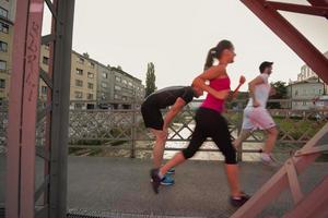 gruppo di giovani che fanno jogging attraverso il ponte foto