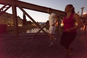 coppia che fa jogging attraverso il ponte della città foto