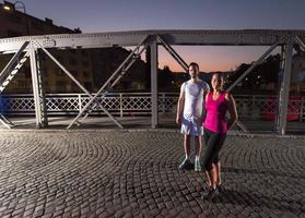 coppia che fa jogging attraverso il ponte della città foto