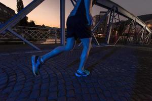 uomo che fa jogging attraverso il ponte della città foto