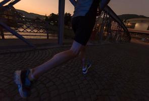 uomo che fa jogging attraverso il ponte della città foto